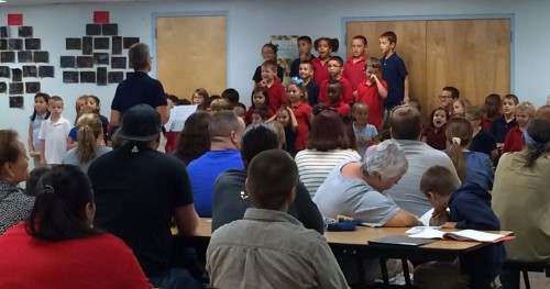 Led by Ms. Dokken, 1st and 2nd graders perform for a full crowd. 